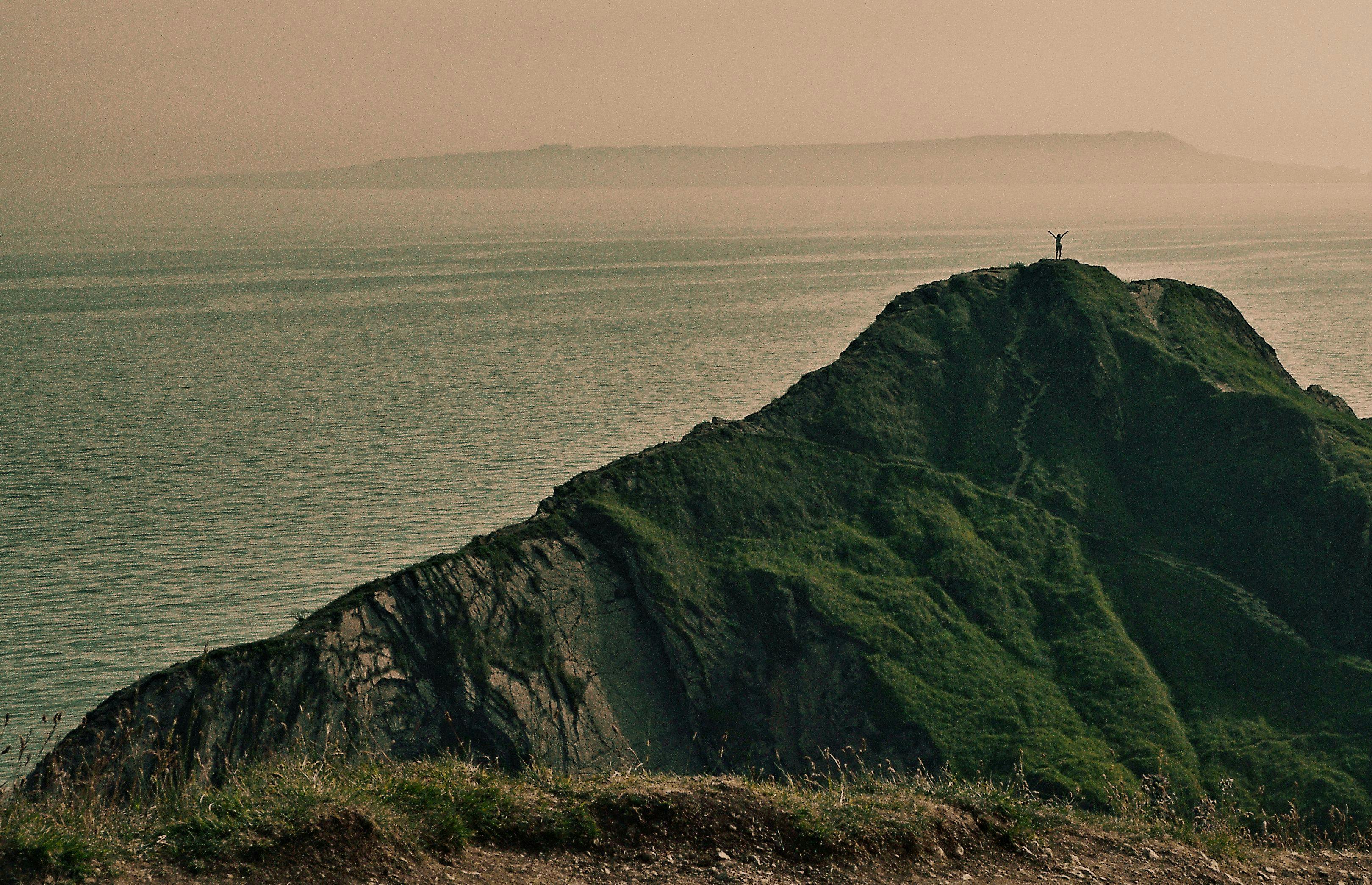 A close-up of a person holding a video game controller with their thumbs on the joysticks.