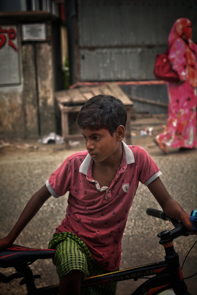 Boy Holding A Bicycle