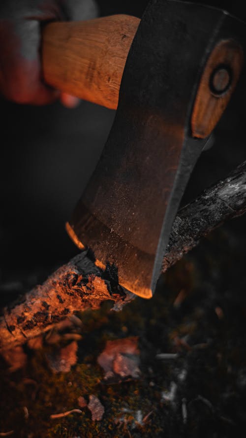 Dark Photo of an Axe Cutting Firewood