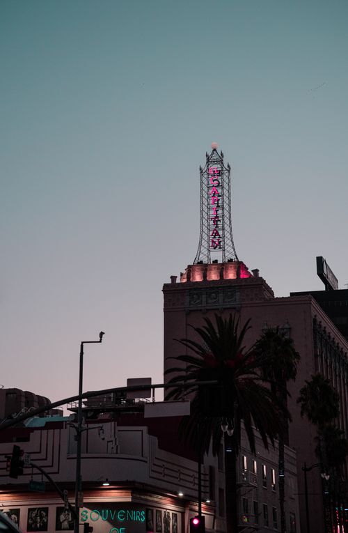 Free View of the El Capitan Theater in Hollywood, Los Angeles lit up at dusk showcasing its neon lights. Stock Photo