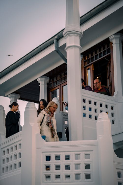 People on White Stairs in Front of House