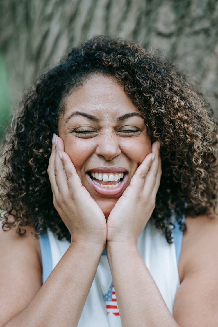 Woman With A Big Smile Holding Her Hands On Her Cheeks 