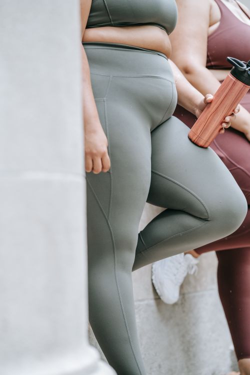 Free Close-up of women in activewear standing outdoors with water bottle. Stock Photo