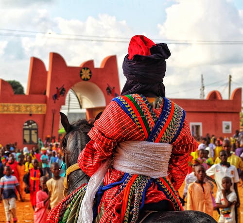 A Man in Colorful Outfit Riding a Horse