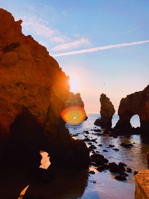 Free Stunning view of dramatic rock arches and seascape during sunset on a Portuguese beach. Stock Photo