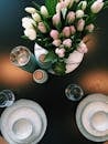 一张桌子的俯视图中，优雅的盘子和郁金香花束作为中心装饰品摆放其上
