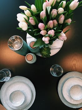 一张桌子的俯视图中，优雅的盘子和郁金香花束作为中心装饰品摆放其上