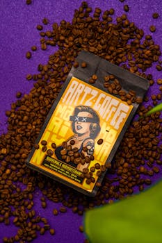 Creative coffee package on purple background with scattered beans.