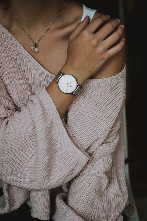 Donna Che Indossa Un Maglione All'uncinetto Beige E Una Foto Del Primo Piano Dell'orologio Analogico Bianco Rotondo