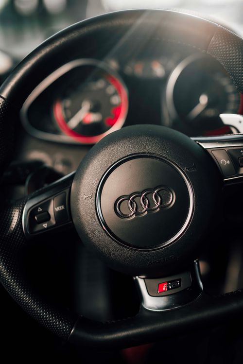 Free Detailed view of an Audi car's steering wheel showing luxury interior design elements. Stock Photo