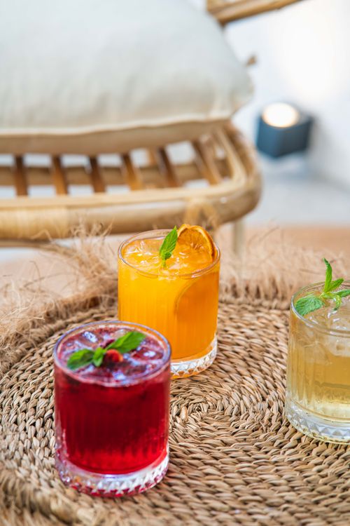 Free Colorful cocktails served on a woven tray create a vibrant and inviting look. Stock Photo