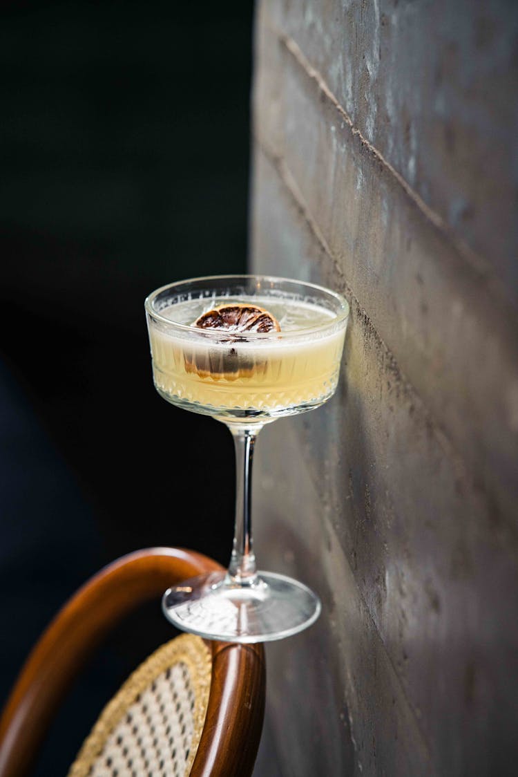 A Glass Of Martini On The Backrest Of A Chair