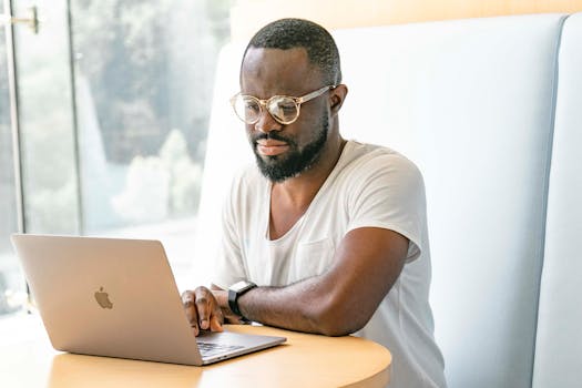 A man using a laptop indoors, showcasing productivity and modern technology.