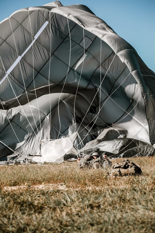 A Military Parachutist Landing on Grass