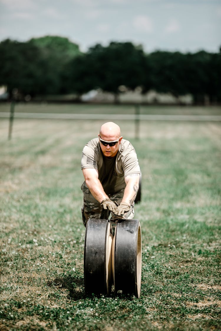 A Soldier Rolling A Wheel On Grass