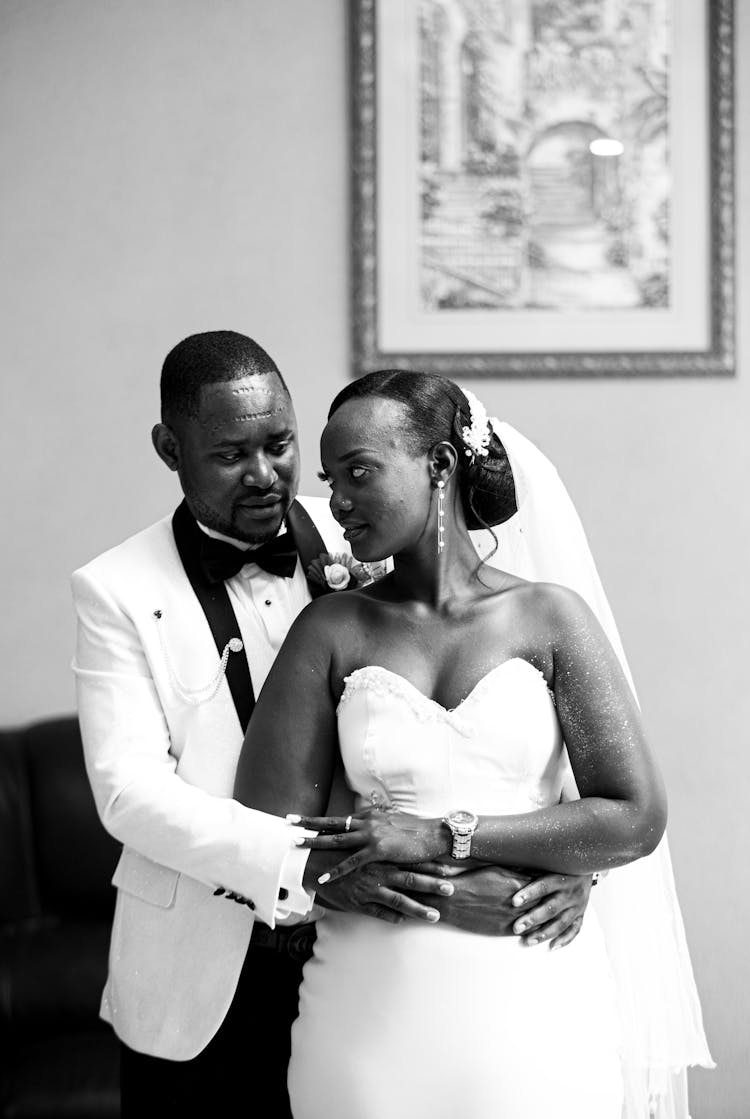 Man In White Tuxedo Embracing A Woman In White Tube Wedding Dress