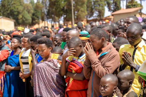 Free A large group of people, including children and adults, praying together outdoors in vibrant clothing. Stock Photo