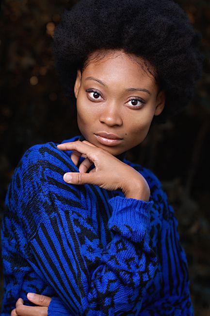 Elegant portrait of an African American woman wearing a vibrant blue sweater.