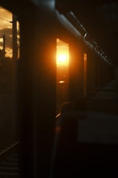 Captivating sunset view from a train window, highlighting urban travel vibes.