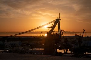 Silhouetted harbour cranes at sunrise — photo by Fakhri Baghirov on Pexels