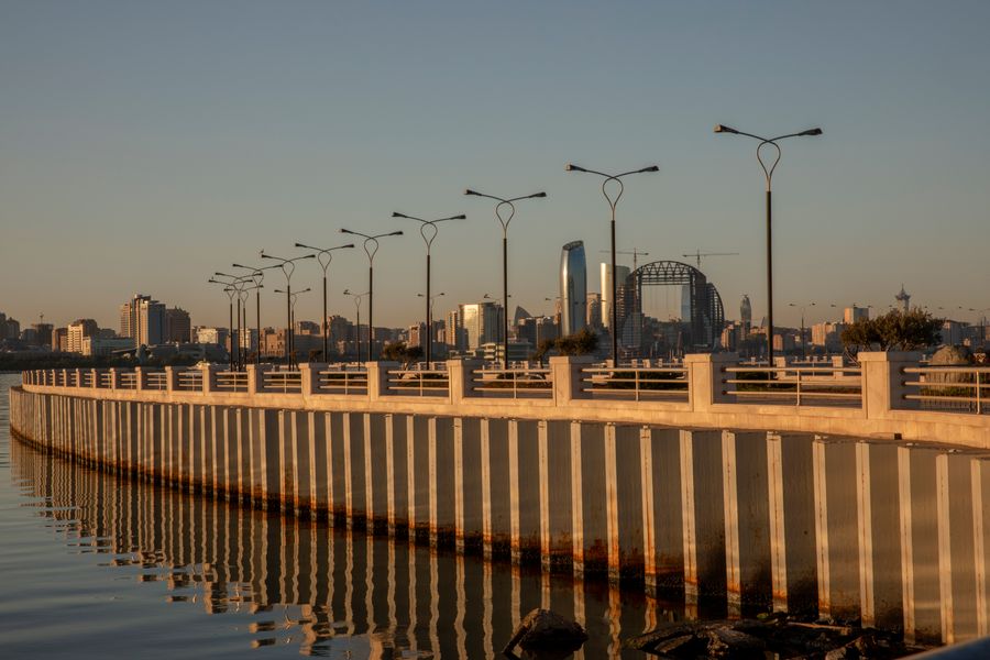 Modern city skyline reflected in a waterfront at dusk — photo by Fakhri Baghirov on Pexels