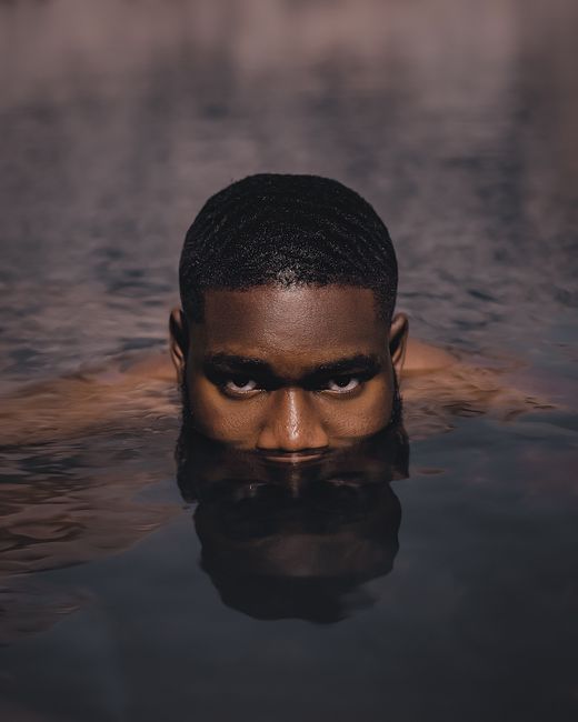 A captivating portrait of a man submerged in water, creating an artistic and enigmatic atmosphere.