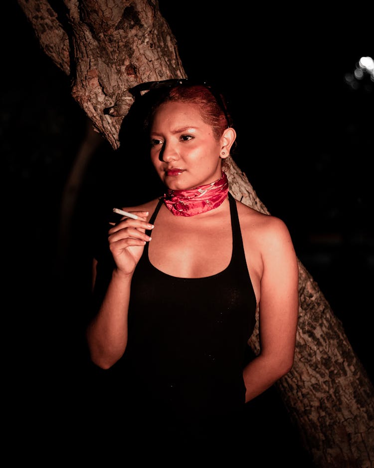 Woman Smoking Near Tree At Night