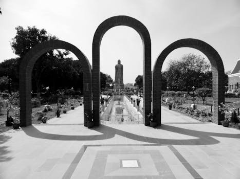 Monochrome image of Buddhist temple with statues and garden in Varanasi.