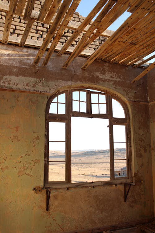 Free View of Desert Land From an Arched Window of an Abandoned Building Stock Photo