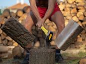 Intense image capturing the powerful motion of chopping wood with an axe outdoors.