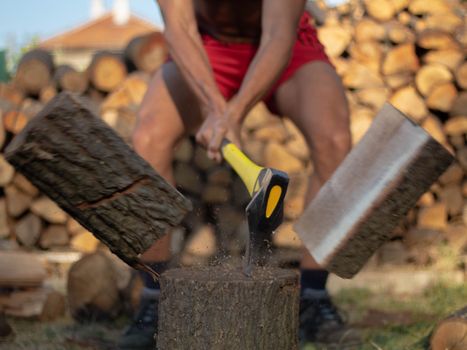 Intense image capturing the powerful motion of chopping wood with an axe outdoors.