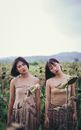 Close-up Photo of Two Women Standing on Sunflower Field