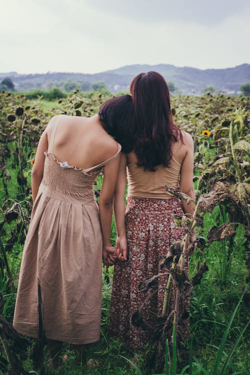 Two Women StandingIn Sunflower Field