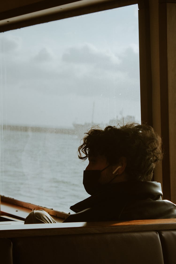 Man With Face Mask Sitting On Ship