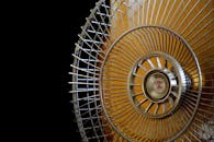 Close-up Photography of Gray Stainless Steel Fan Turned on Surrounded by Dark  Background