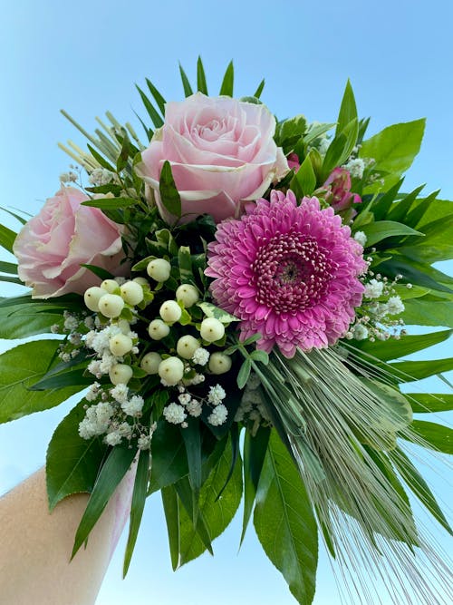 Close-up of a Bouquet of Pink Flowers and Green Leaves 