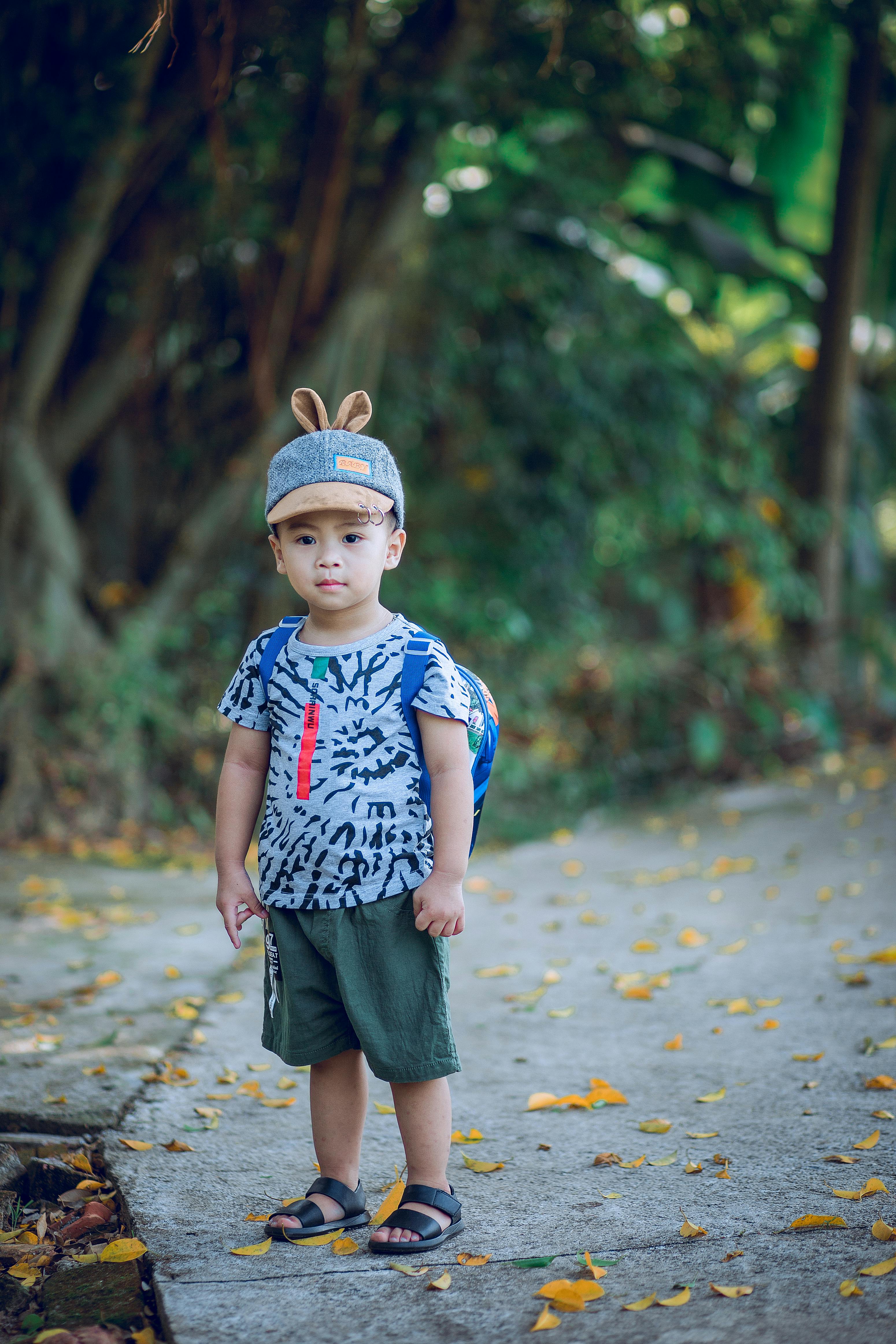 Niño Vestido Con Camiseta Y Mochila De Pie Sobre El Camino De Hormigón · Fotos de stock gratuitas