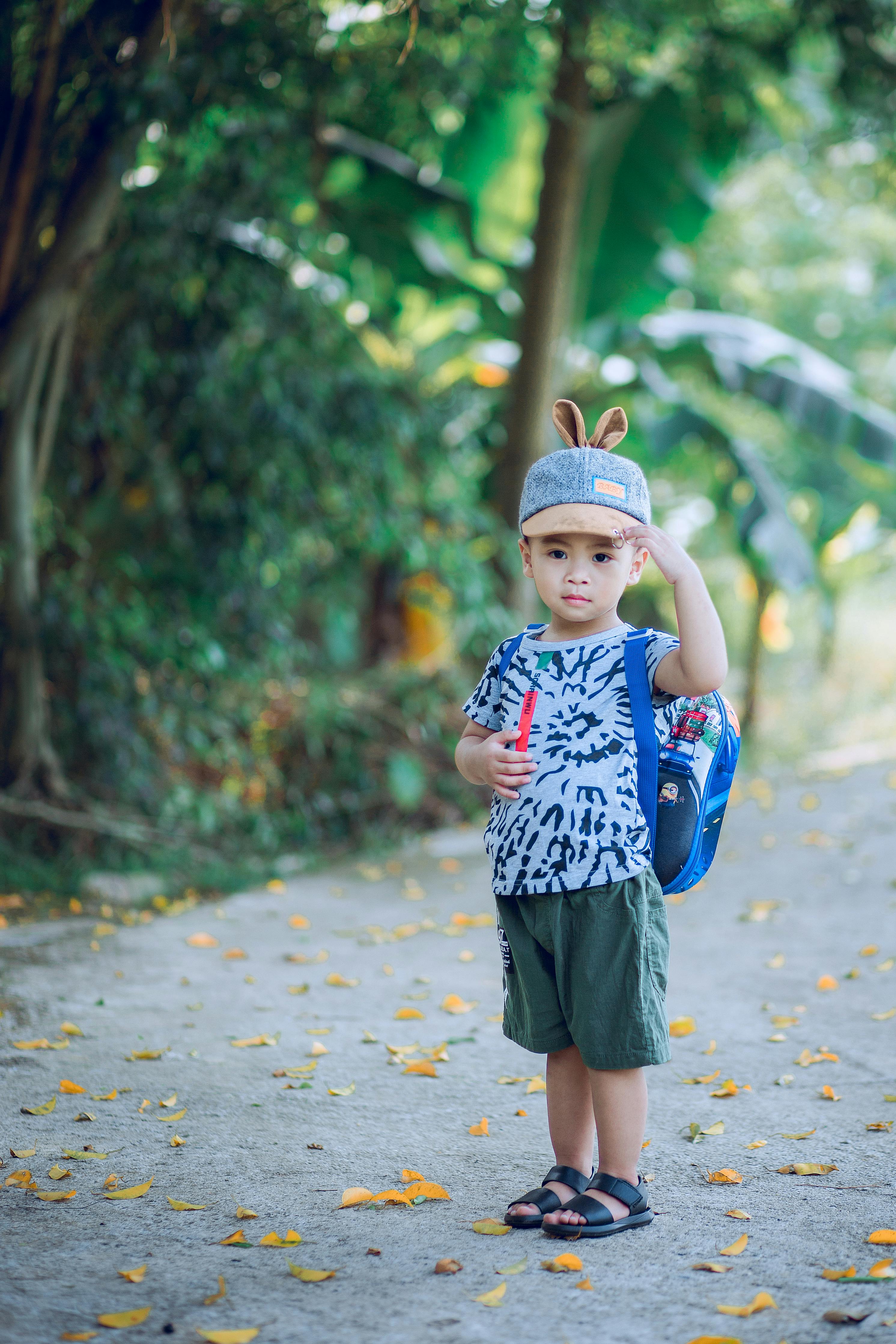 boy wearing shirt and shorts on road