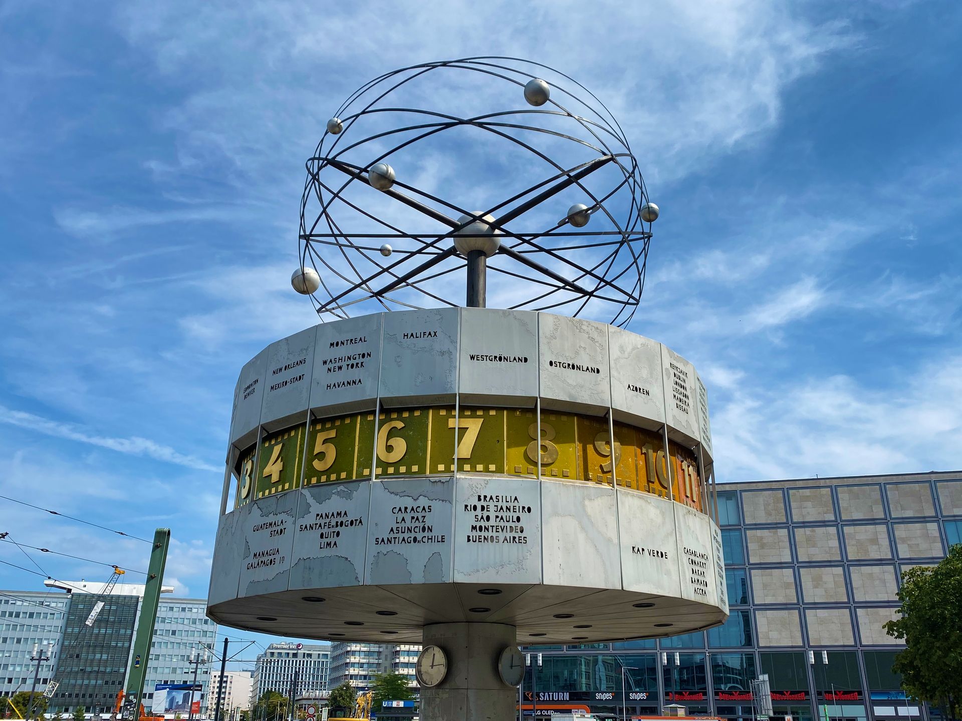 Iconic image of Berlin's World Clock at Alexanderplatz under a vibrant blue sky.