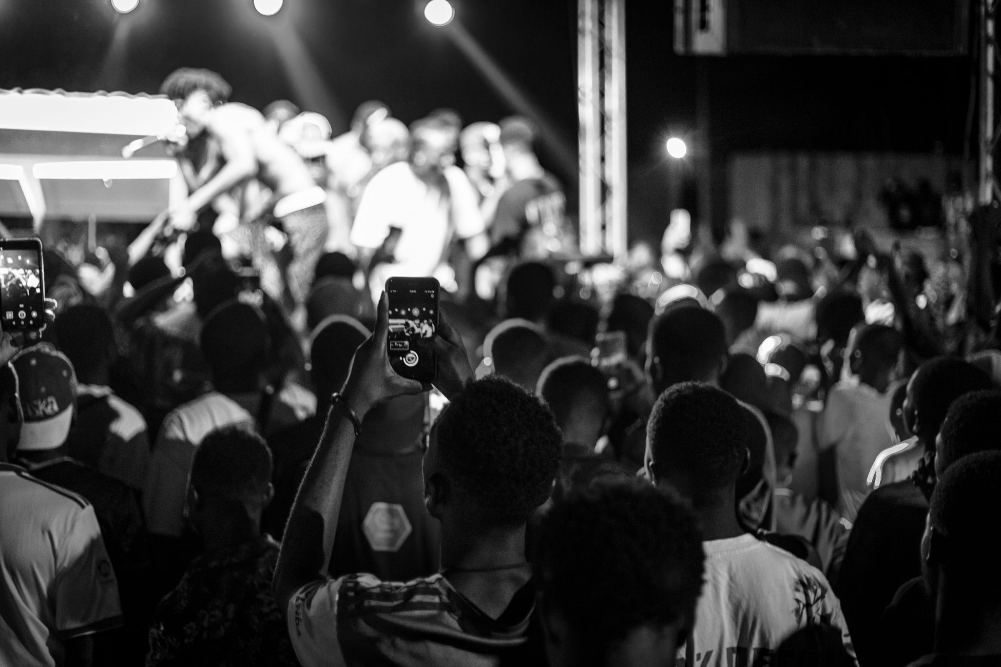 Vibrant live concert with crowd and performers captured in monochrome tone.