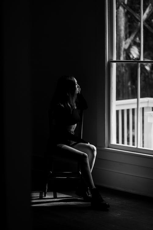 Woman Sitting on Chair Near Window