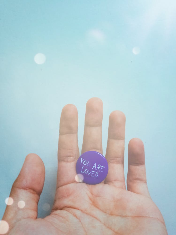 Person Holding Purple Badge You Are Loved Text-printed