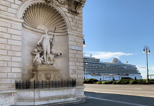 A striking composition of a classical statue and a modern cruise ship in Trieste, Italy.