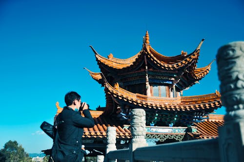 A Man in Black Jacket Taking a Picture