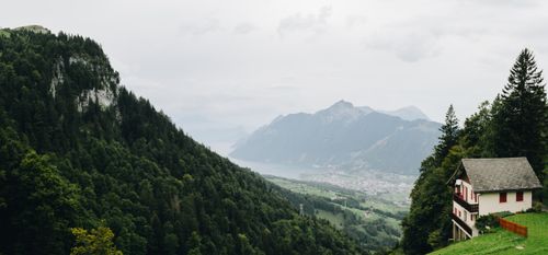 Free Breathtaking view of Swiss mountains, valley, and traditional chalet nestled among lush greenery. Stock Photo