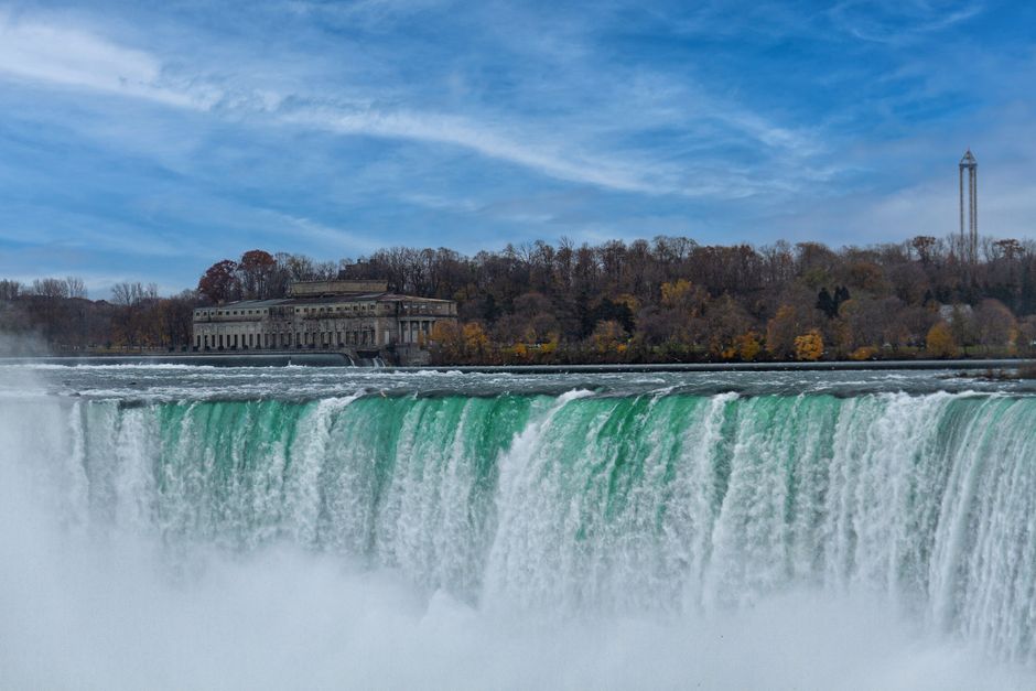 NF USA - Luxury Helicopter Tour with Maid of the Mist & Lunch - Stunning view of Niagara Falls with autumn foliage, showcasing natural beauty and power.