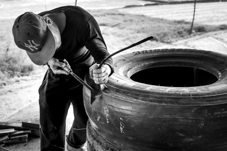 Man In Black Long Sleeve Shirt Fixing A Tire