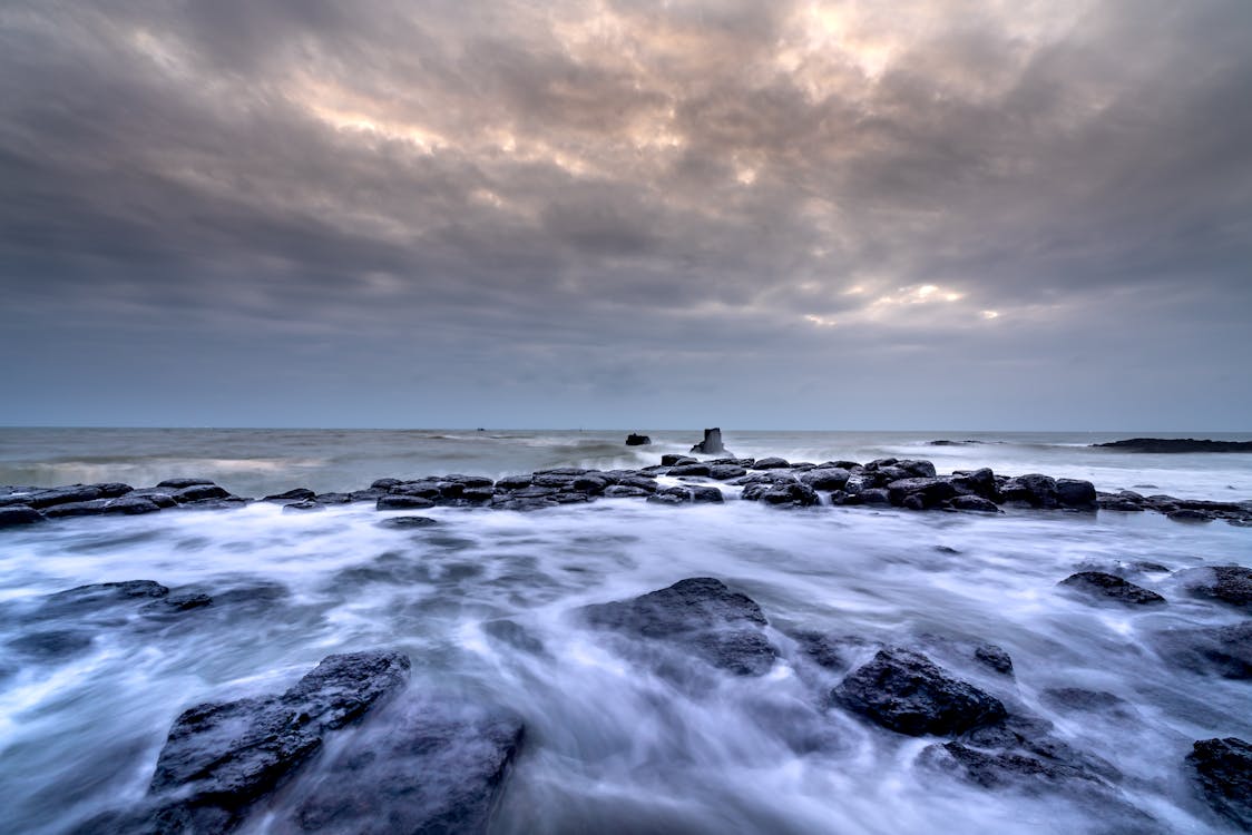 Long Exposure Photograph of Rocks on a Seashore