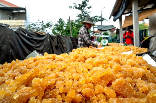 Free Asian vendor selling crystalline goods at an outdoor market stall. Stock Photo
