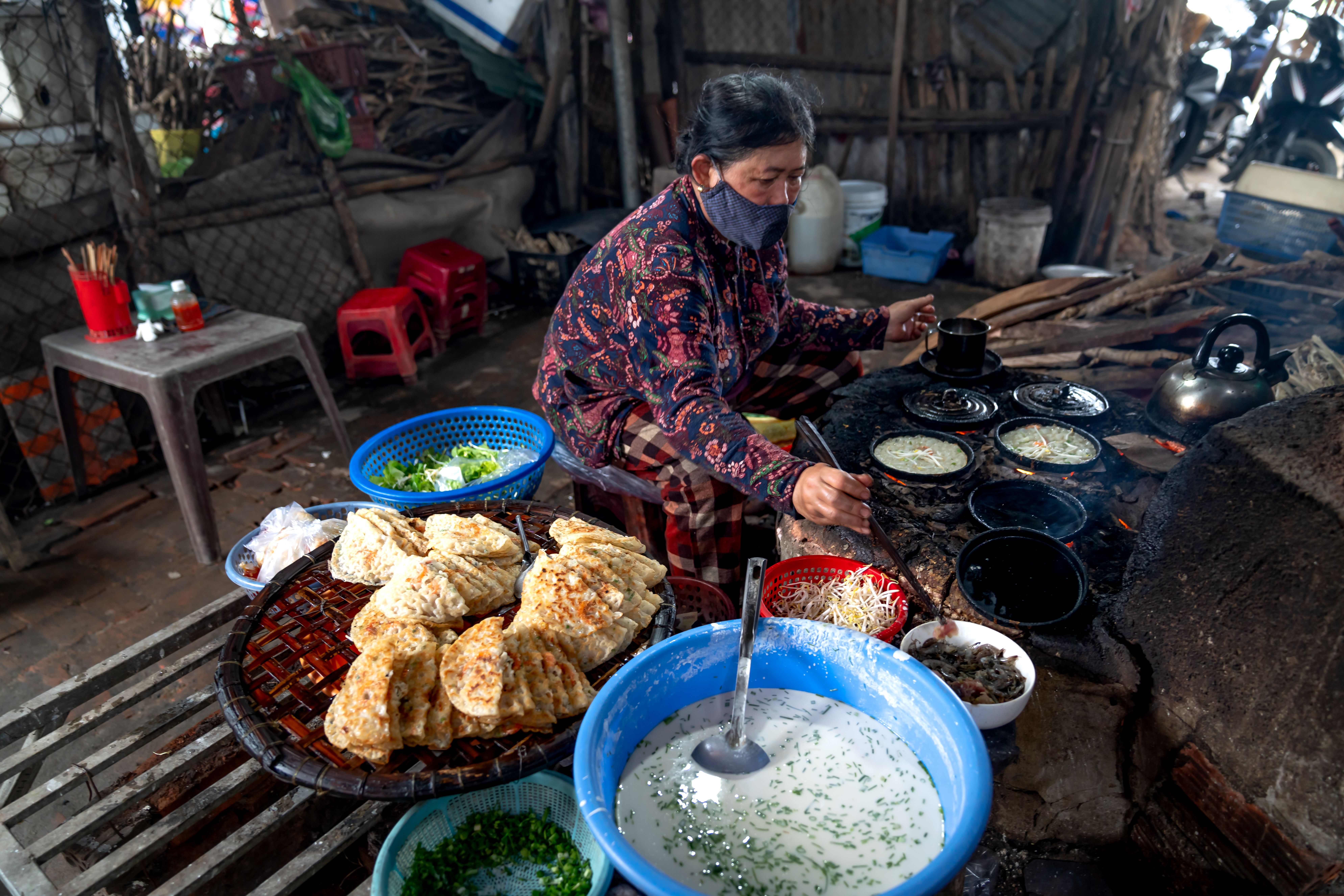 Street Food Vendor Cooking on Stone Stove · Free Stock Photo